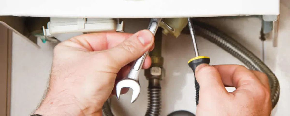Boiler repair technician tightening pipe fittings and connections in Harrisburg, PA