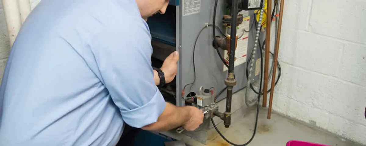 Furnace repair technician inspecting and servicing a home heating system in Harrisburg, PA