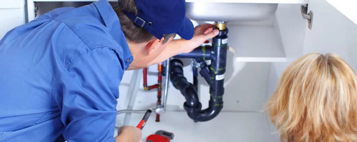 Plumber repairing under-sink drain pipes and fittings in Harrisburg, PA